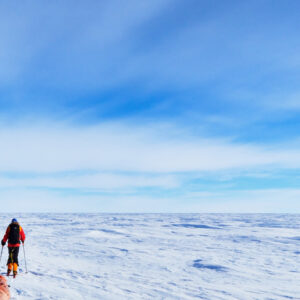 Ski South Pole guest Bob M. pulls his sled across polar plateau.