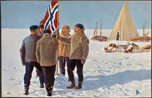 A group of men in fur coats stand by a Norwegian flag in Antarctica’s snowy landscape, with a tent and sled dogs resting nearby under a clear blue sky.