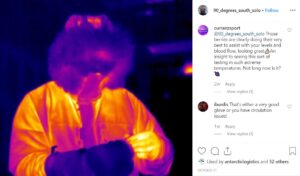 A thermal image shows a person in cold surroundings—perhaps near the South Pole—their head and upper body glowing warm (yellow, red, purple) while their hands appear much cooler. Instagram comments are visible on the right side.