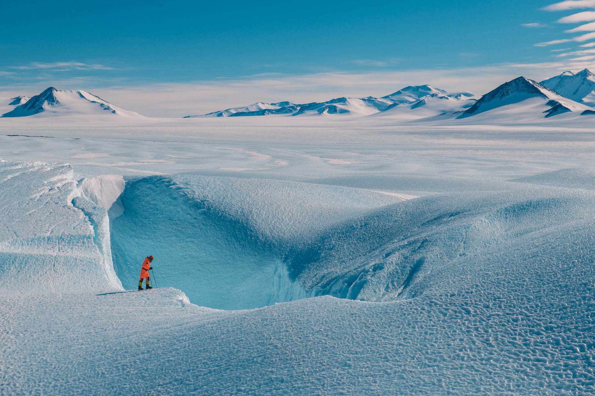 A guest peers over an ice formation at the Drake Icefall