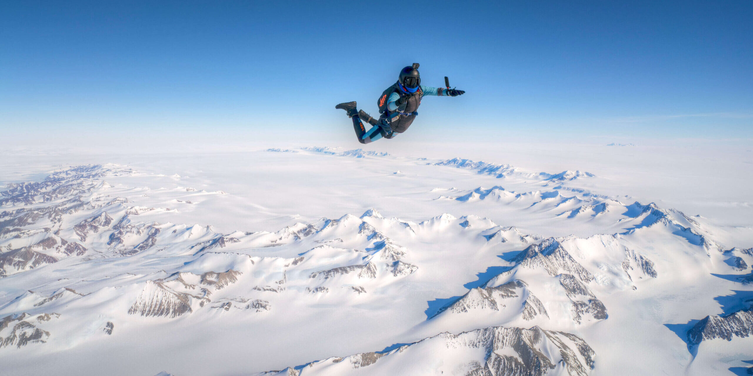 A skydiver free falls over Union Glacier